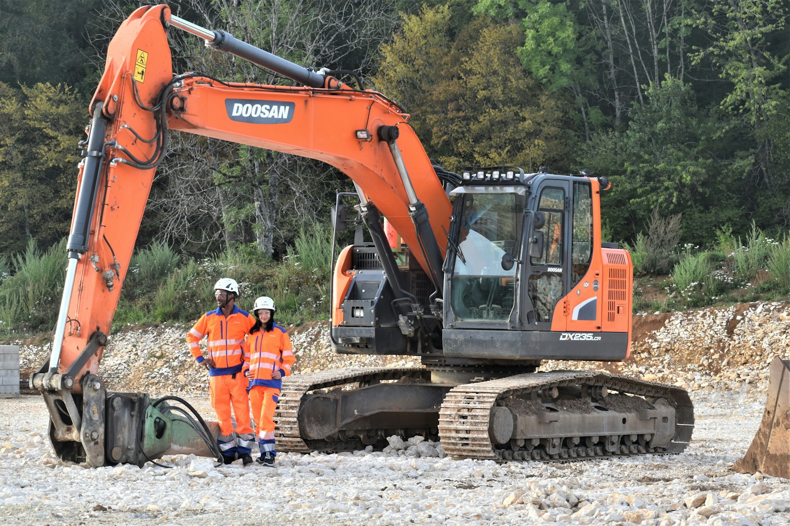 a couple of men standing next to a construction vehicle